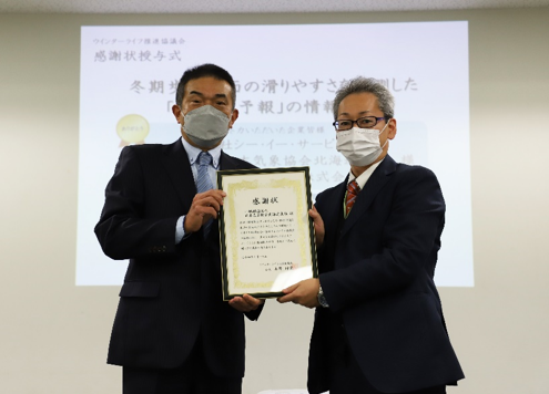 授与式の様子 (写真右)日本気象協会北海道支社 支社長 川上俊一